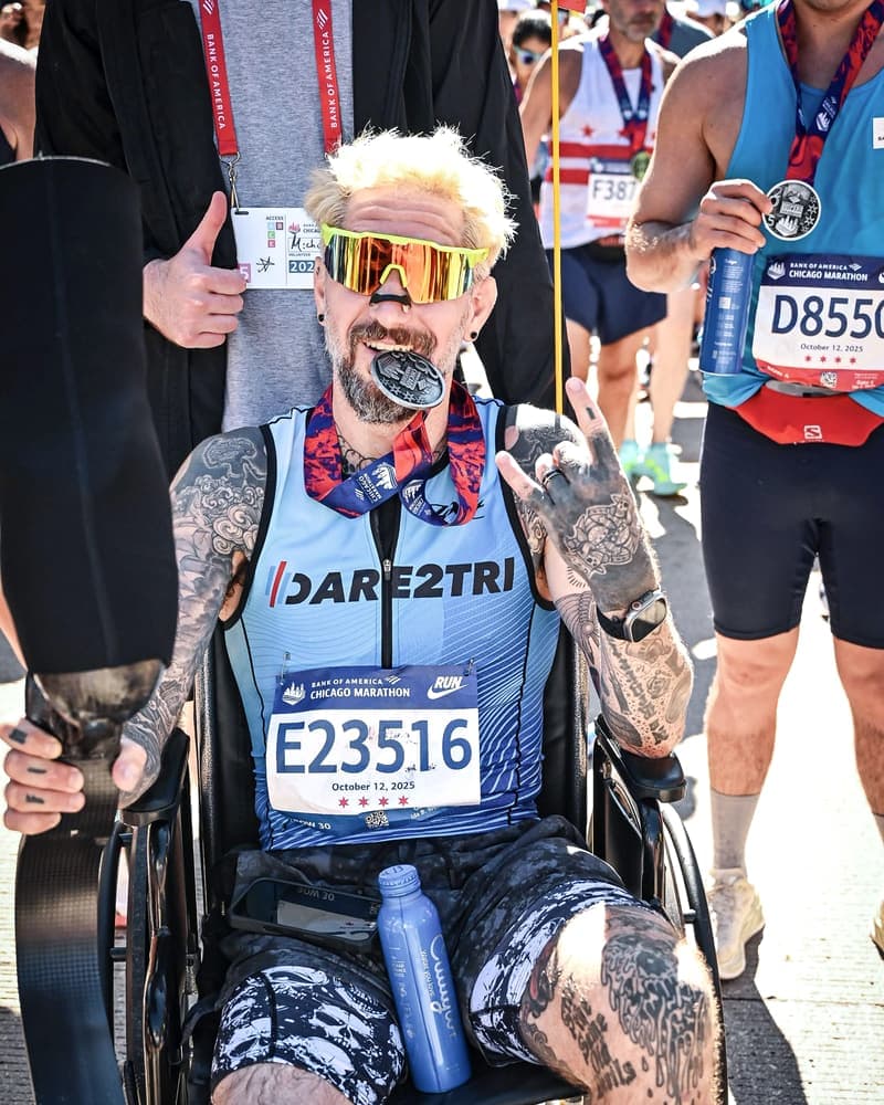 After the finish, in a wheelchair with the medal between my teeth and my running blade across my lap